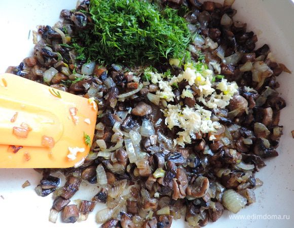 Первым делом займемся грибной начинкой. Шампиньоны мелко нарезаем, выкладываем на раскаленную сухую сковороду, держим их там до испарения жидкости, затем уменьшаем огонь, добавляем растительное масло и мелконарезанный лук. Жарим до готовности лука.
Затем добавляем мелконарезанный укроп, чеснок, выдавленный через пресс, солим по вкусу.
Я еле остановила себя, чтоб не съесть все сразу)