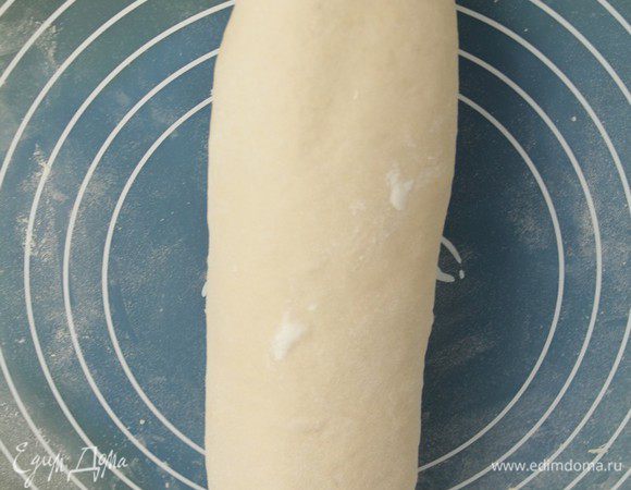 Раскатать тесто в прямоугольник, скрутить в длинный рулет, защипнуть края и уложить швом вниз. Накрыть и оставить на 45 мин. 
