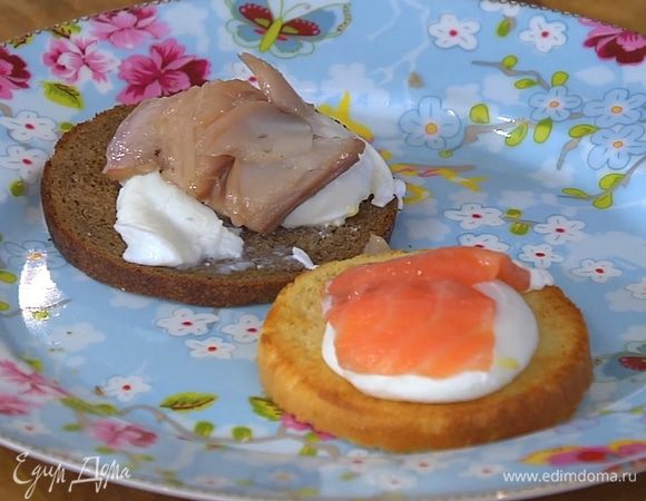 На каждый тост выложить по яйцу пашот, на бородинский хлеб поместить кусочек скумбрии, на бриошь — семгу.