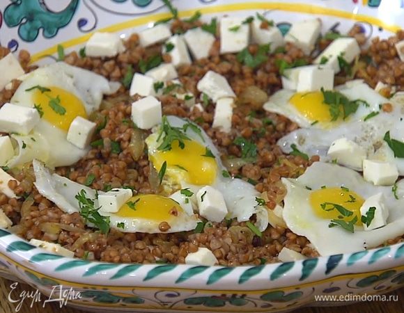 Сверху на гречку с сыром выложить перепелиные яйца и посыпать оставшимся сыром и зеленью.