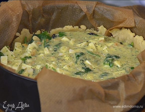 Вынуть подпеченный корж из духовки, удалить бумагу с горохом, на тесто выложить шпинат с луком, сверху вылить яичную массу с козьим сыром. Выпекать пирог еще 25–30 минут.