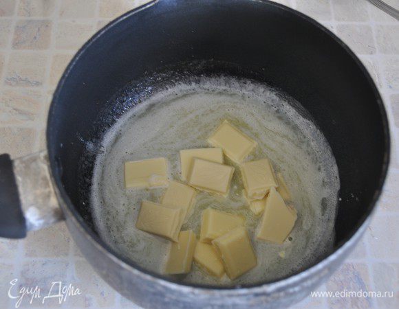 Испечем корж из белого шоколада. Включить разогреваться духовку до 180 градусов. 
В общем, тесто заводится почти также как на темный корж, но масло будем подмешивать иначе, чтобы сохранить воздушность теста.
В небольшом сотейнике растопить сливочное масло, добавить поломанный на кусочки белый шоколад. Размешать до расплавления шоколада. Оставить остывать.