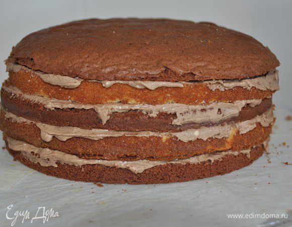 Затем белый корж, промазываем кремом. Накрываем темным коржом. Так чередуем белый корж, крем, темный корж.