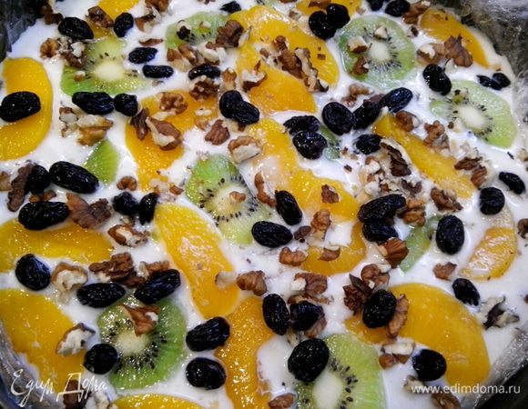 Посыпаем орешками и изюмом, заливаем творожным слоем.