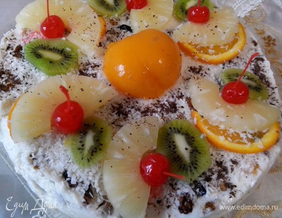 Украшаем торт. Посыпаем кокосовой стружкой, выкладываем фрукты и слегка посыпаем тертым шоколадом.