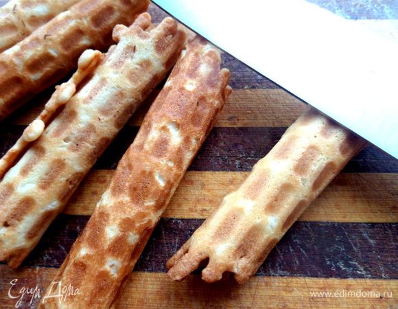 И тут же быстро сворачиваем в плотную трубочку, прижимаем лопаткой и держим пару секунд. Удобно печь вафли вдвоём: один печёт, второй быстро подхватывает и сворачивает!