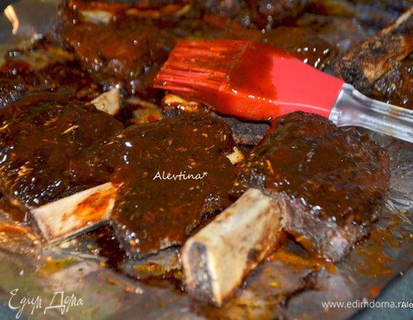 По истечении времени смазать ребра со всех сторон в готовом купленном или домашнего приготовления барбекю соусе и вернуть в духовку на 30 мин.