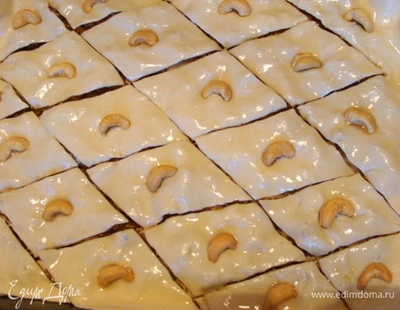 Накрыть последним слоем теста, смазать его растительным маслом, порезать на ромбики, но только первые три слоя, последний слой теста (нижний) нужно оставить не тронутым!
Украсить орешками и поставить в разогретую духовку на 10-15 минут при 200*