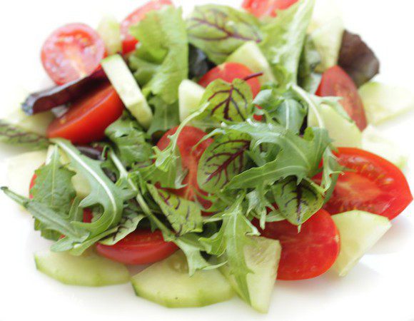 На тарелки выложить горсти руколы, мангольда, кружочки огурца , дольки помидоров и тонко порезанный лук.