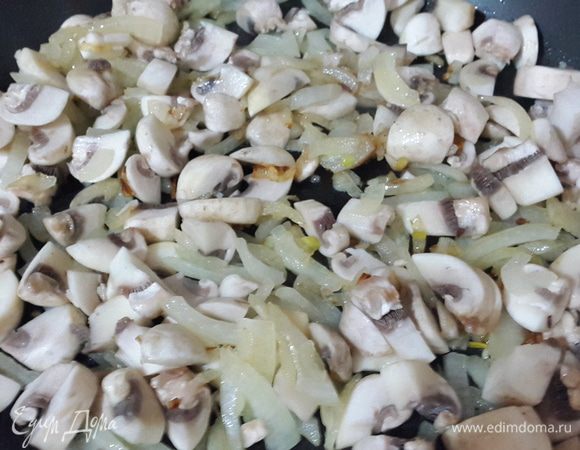 Репчатый лук нарезать и обжарить на смеси масла от вяленых томатов и оливкового до мягкости и золотистого цвета. Затем к нему добавить нарезанные шляпки шампиньонов, перемешать и обжаривать до выпаривания жидкости.