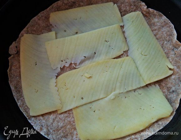 В смазанную тефлоновую форму (22 см) положить одну цельнозерновую тортилью,сверху разложить сыр (или насыпать тёртый - это не принципиально!).
Если накрыть второй лепёшкой и обжарить с двух сторон - получим быстрейший полноценный завтрак, которым я увлеклась последнее время под кофе)