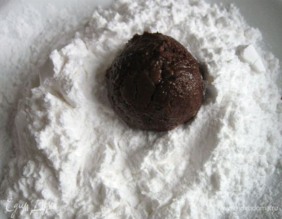 Поместить шоколадное тесто в холодильник минимум на 3 часа. Тесто несколько уплотнится. 
Разогреть  духовку до 180˚C. В плоскую тарелку насыпать сахарную пудру. Ложкой взять  кусочек теста,  скатать  из него небольшой  шарик (диаметром 2,5 см). Обвалять со всех сторон сахарной пудрой. 
