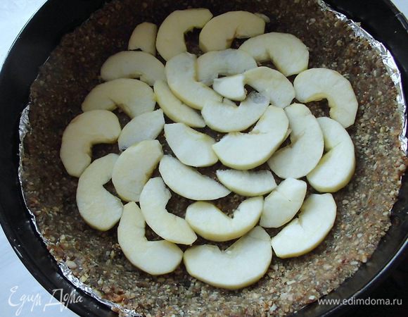 Из яблока вырезать сердцевину, очистить его от кожуры. Нарезать тонкими ломтиками и сбрызнуть лимонным соком. Яблоко лучше брать кислое, т. к. пирог в целом получится сладким. Выложить яблоко на основу. 