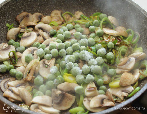 Добавить зеленый горошек, продолжая обжаривать.