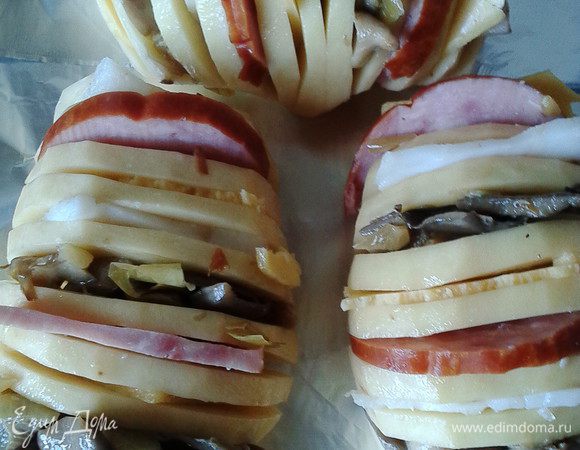 Картофель посолить, поперчить (по вкусу), а в разрезы поочередно вставлять слайсы ветчины, сыра, грибов( можно использовать сырые шампиньоны, а можно, как я, брать обжаренные с лучком вешанки),сальца (по желанию, для кого слишком калорийно, можно обойтись и без сала)