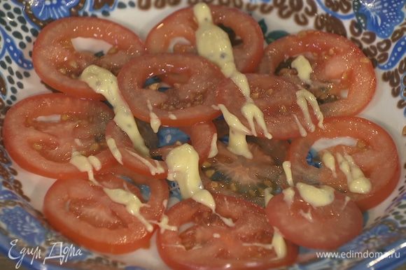 На блюдо тонким слоем уложить помидоры, слегка смазать их майонезом, немного посолить и поперчить.