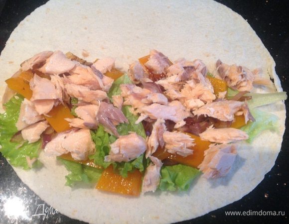 На половину лепешки выложите листья салата, лук с болгарским перцем, лосось (ломтиками) и натертый сыр. Накройте второй половинкой...