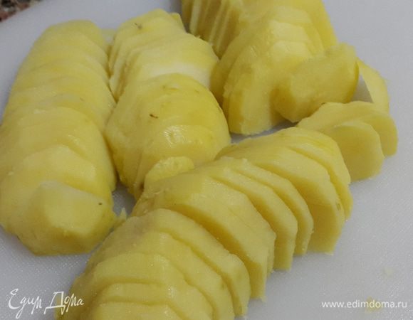 Тем временем чистим отваренный в мундире картофель и режем его пластиками.