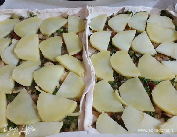 Тесто тонко раскатываем и выкладываем на противень застеленный бумагой для выпечки.

Далее выкладываем на тесто, равномерно распределяя, половину начинки, а
сверху пластики картофеля, немного солим .