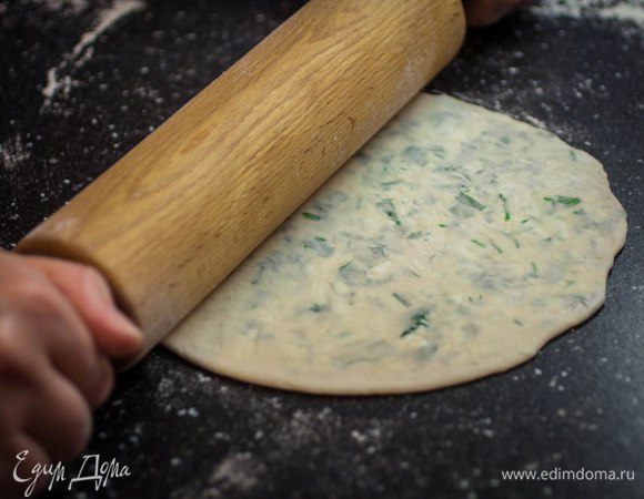 Колобок слегка приплюснуть ладонью, а затем при помощи скалки раскатать в тонкую лепешку. От избытка воздуха можно избавиться, проткнув лепешку ножом или вилкой.