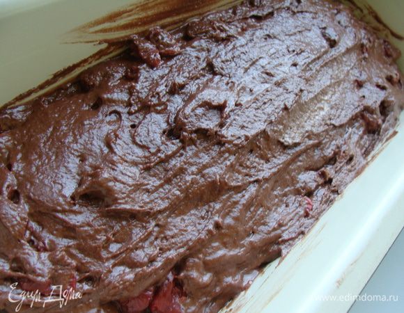 Затем в массу добавляем по одному яйца. Каждый раз тщательно взбивая. Муку просеять с какао и разрыхлителем. Перемешать. Вишню откинуть на сито и добавить в тесто. Сироп сохранить. Выложить тесто в смазанную форму.