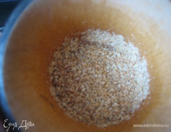Кунжут обжарить на сковородке до золотистого цвета, остудить до тёплого состояния, переложить в ступку, слегка истолочь.