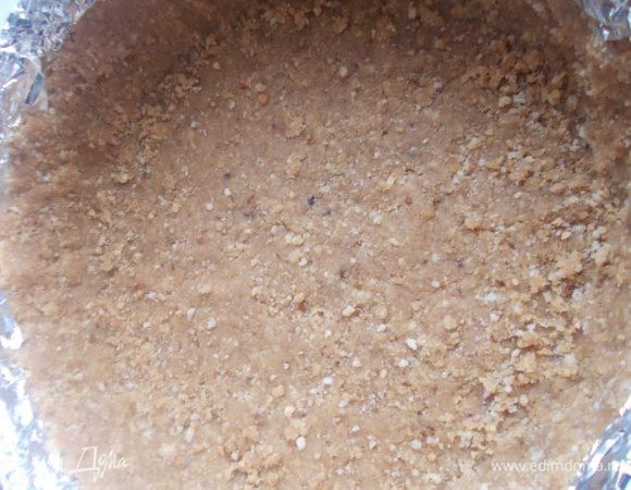 Форму для выпечки (21 см) облепляем со всех сторон нашим печеньем, плотно его прижимая, не забываем и про бортики. Их можно аккуратно срезать по уровню, чтобы было ровно, а можно как сделала я - оставить рваные краешки. Отправить в холодильник для застывания, а пока будет готовится творожный слой.