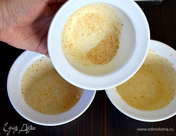 Порционные формочки для запекания смазать оливковым маслом и присыпать панировочными сухарями.