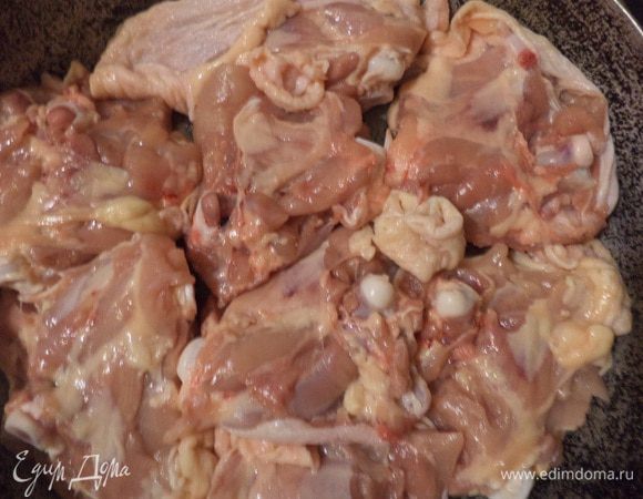 Куриные бёдра вымыть, обсушить бумажным полотенцем и выложить в смазанную растительным маслом форму для запекания кожицей вниз.