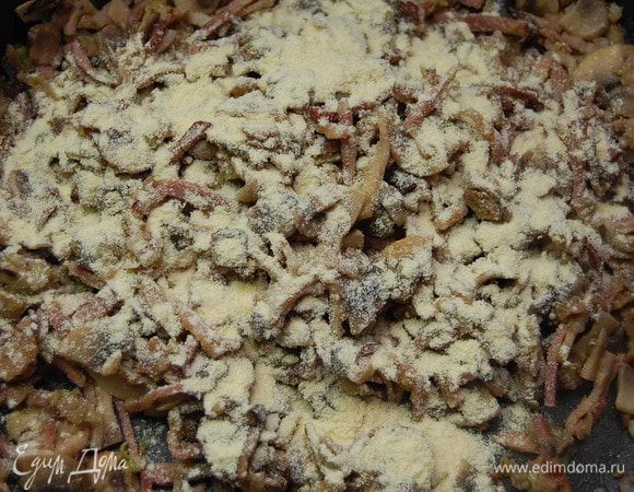 Содержимое сковороды присыпать мукой, тщательно перемешать. Подержать на тихом огне еще 3 минуты.