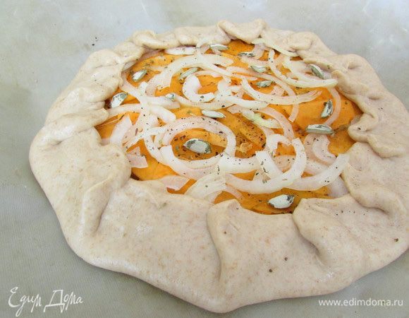 Присыпать галету луком, прованскими травами и тыквенными семечками. Сбрызнуть растительном маслом, посолить и поперчить. Заправить края галеты и отправить в разогретую духовку (180 градусов) до готовности - до легкого зарумянивания.