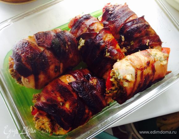 На мясо выкладываем начинку, кладем полосочки перчика, сворачиваем в рулетик. Рулетик оборачиваем двумя полосочками бекона и складываем в смазанную оливковым маслом форму для запекания.