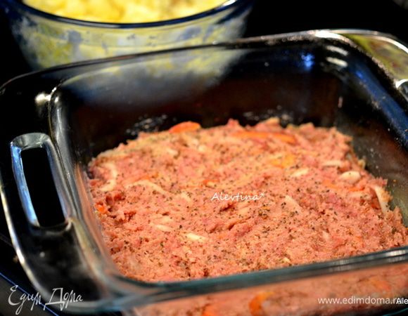 Разделить поровну смешанный мясной фарш, выложить первую часть на дно формы и распределить.
