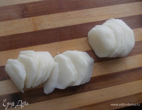 Картофель порезать пластинками. Можно порезать ножом очень тоненько, а можно воспользоватся шинковкой для капусты.