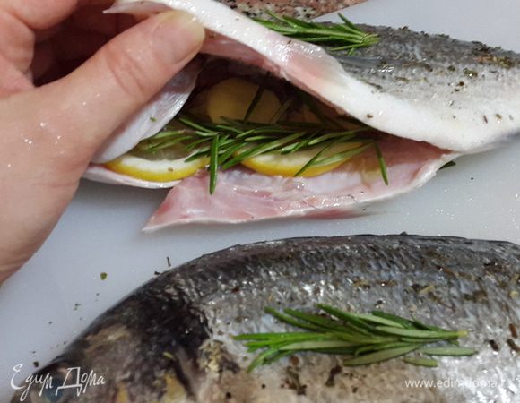 В брюшко каждой рыбины вложила дольки лимона, имбирь и нижнюю часть веточки розмарина. Верхнюю часть веточки выложила на рыбу сверху.