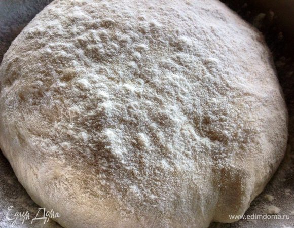 На доску просеиваем еще примерно 1 стакан муки, выкладываем в нее тесто и замешиваем так, чтобы воздух выходил из него, снова под полотенце и в сторонку. 