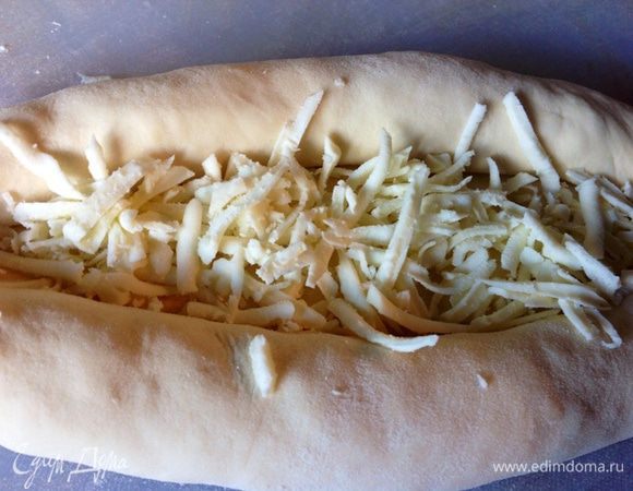 В середину этой лодочки еще немного сулугуни.
На противень стелим лист пергаментной бумаги и НЕ смазываем его маслом, а посыпаем немного мукой. На лист с мукой выкладываем хачапури и в разогретую духовку 180-190С на 20 мин.