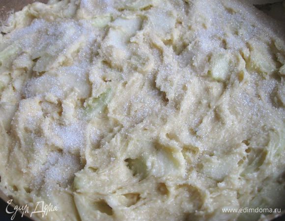 Духовку разогреть до 170С. Яблоки разрезать на четвертушки, почистить, удалить семенную часть, тонко нарезать, добавить в тесто. Перемешать, положить в разъемную форму, застеленную бумагой для выпечки, борта тоже закрыть бумагой. Сверху посыпать (по желанию, для тонкой карамельной корочки) сахарным песком (1 столовая ложка). 