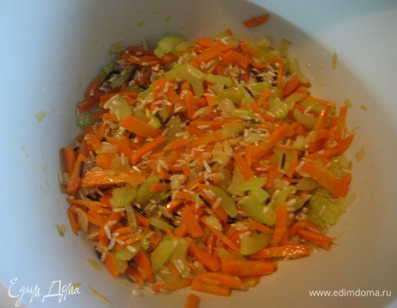 Морковь нарезать соломкой. Сельдерей, с помощью овощечистки, очистить от грубых волокон, нарезать произвольно. Добавить овощи к луку, продолжать обжаривать еще в течении 5 минут.