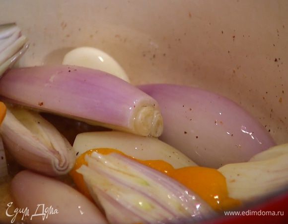 Обжаренное мясо переложить в другую посуду, а в кастрюлю отправить цедру апельсина, шалот и чеснок и обжарить до золотистого цвета.