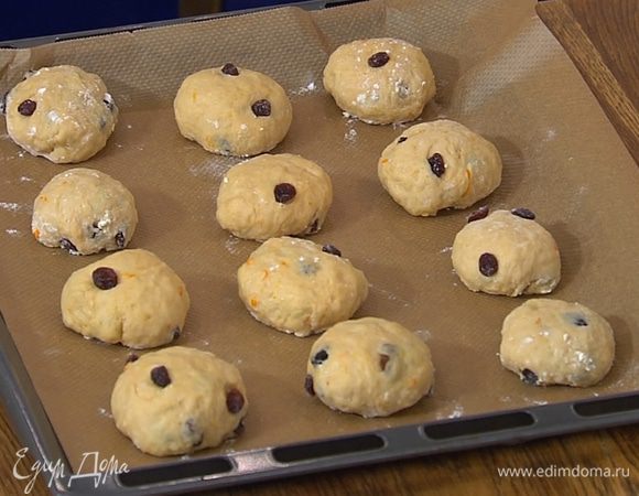 Противень выстелить бумагой для выпечки, выложить булочки, накрыть влажным полотенцем и оставить на 10–15 минут для расстойки.