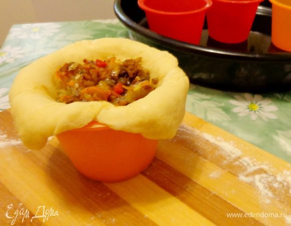 Смазать формочки для куличей, раскатать тесто и разложить его по формочкам. На тесто выложить начинку.