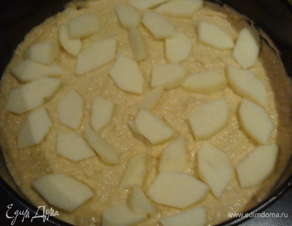 Дно формы застелить бумагой для выпечки, смазать растительным маслом. Яблоко очистить и нарезать на небольшие  кусочки. Часть теста выложить в форму, затем выложить кусочки яблок. На начинку равномерно уложить оставшееся тесто.