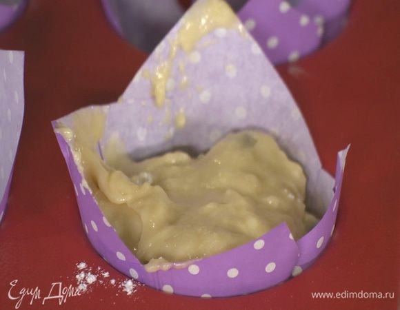 В формы для маффинов вставить бумажные вкладыши и разложить тесто.