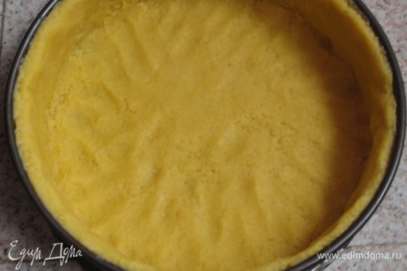 Разъёмную форму диаметром 24 см смазать сливочным маслом и присыпать мукой. Раскатать тесто и выложить в форму, формируя бортики. Лишнее тесто обрезать.