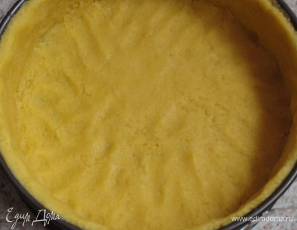 Разъёмную форму диаметром 24 см смазать сливочным маслом и присыпать мукой. Раскатать тесто и выложить в форму, формируя бортики. Лишнее тесто обрезать.