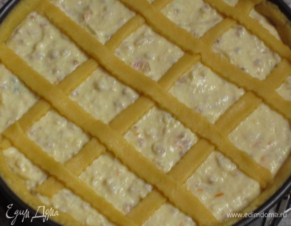 Оставшееся тесто раскатать, нарезать полоски шириной 1,5 см и выложить в виде решётки на пирог.