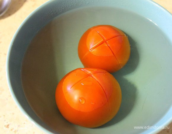  Помидоры надрезать сверху, залить кипятком и оставить на 1 минуту. Затем снять кожуру. 