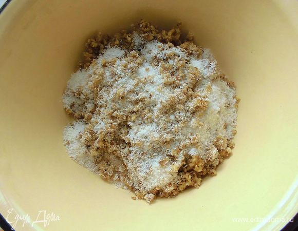 С фиников слить воду, достать из них косточки. Финики и грецкие орехи измельчить в мясорубке. Добавить кокосовую стружку и перемешать. Я предварительно замачивала 1 стакан орехов, хотя это было необязательно, т.к. пирог и так в любом случае получится сочным. 