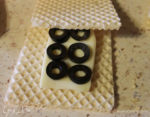 Теперь берем один вафельный квадрат, кладем на него ломтик сыра, 6 кружочков маслин, накрываем вторым вафельным квадратом. Обмакиваем с двух сторон в кляре и обжариваем на среднем огне с двух сторон до золотистой корочки.